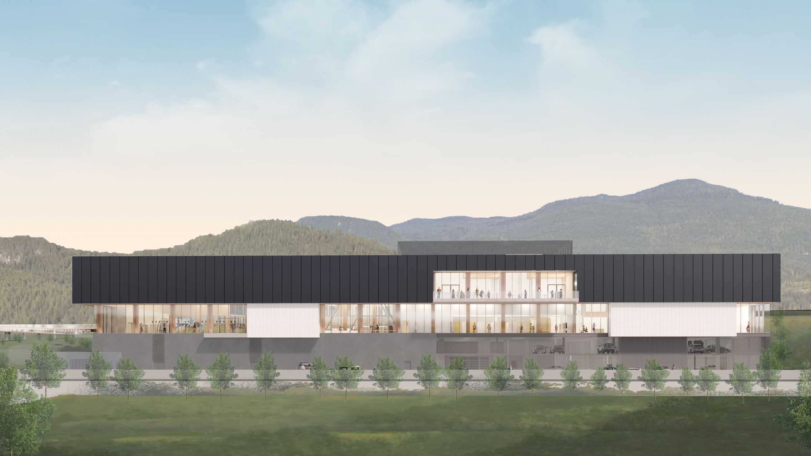 Burke Mountain Community Centre wide elevation rendering — two-storey facility with dark cladding and warm-wood interior glow, mountains in the background