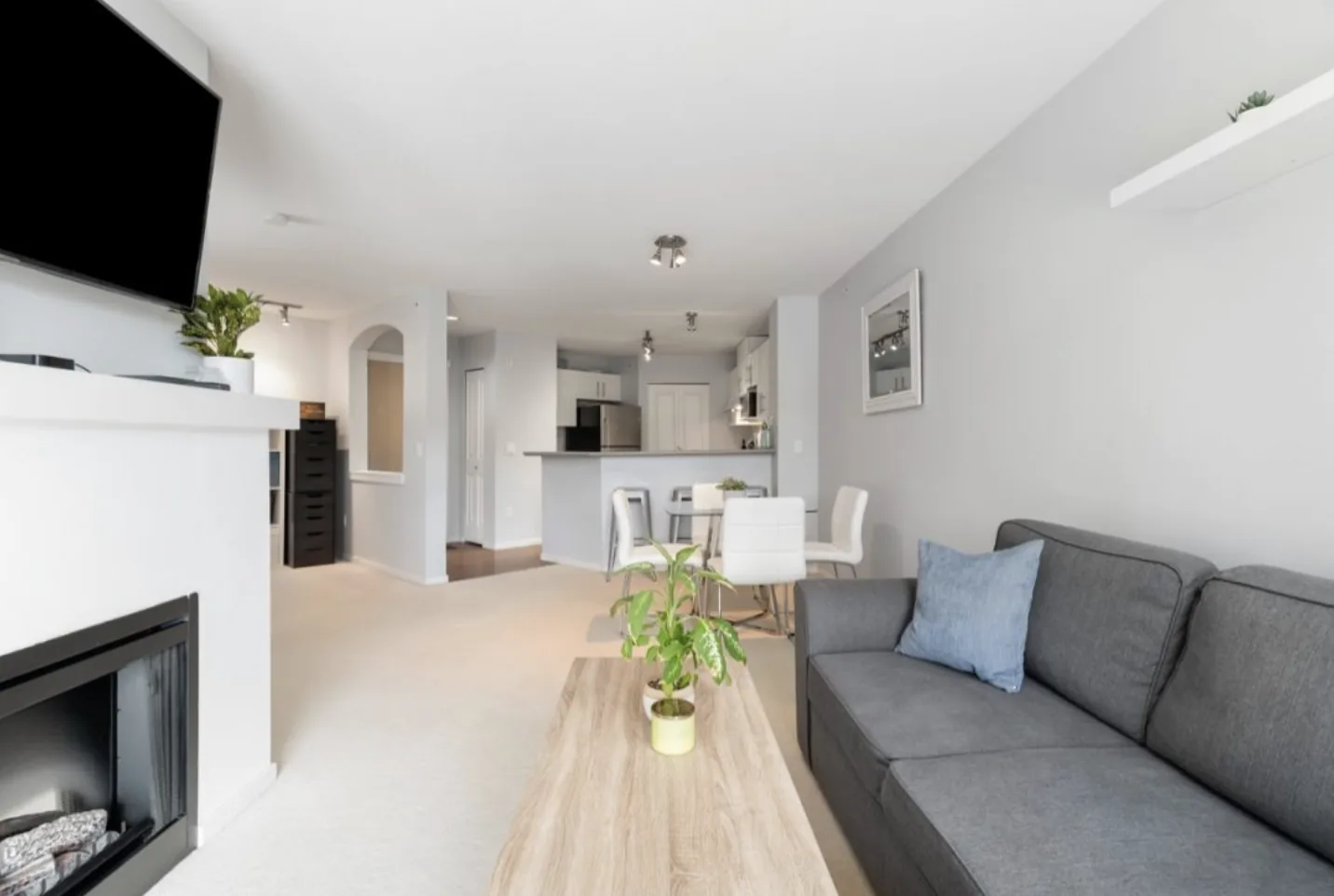Interior of a previously sold Klahanie one-bedroom condo — open layout with fireplace, kitchen sightline, and living room