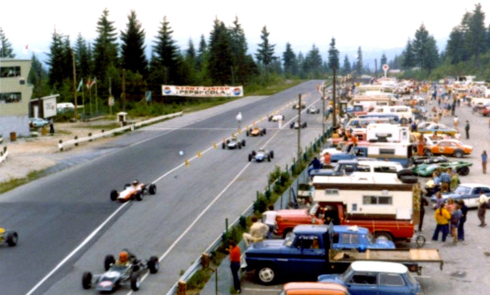 The Westwood Motorsports Park paddock on a race weekend — drivers, crews, and spectators around the grid before a club race start.