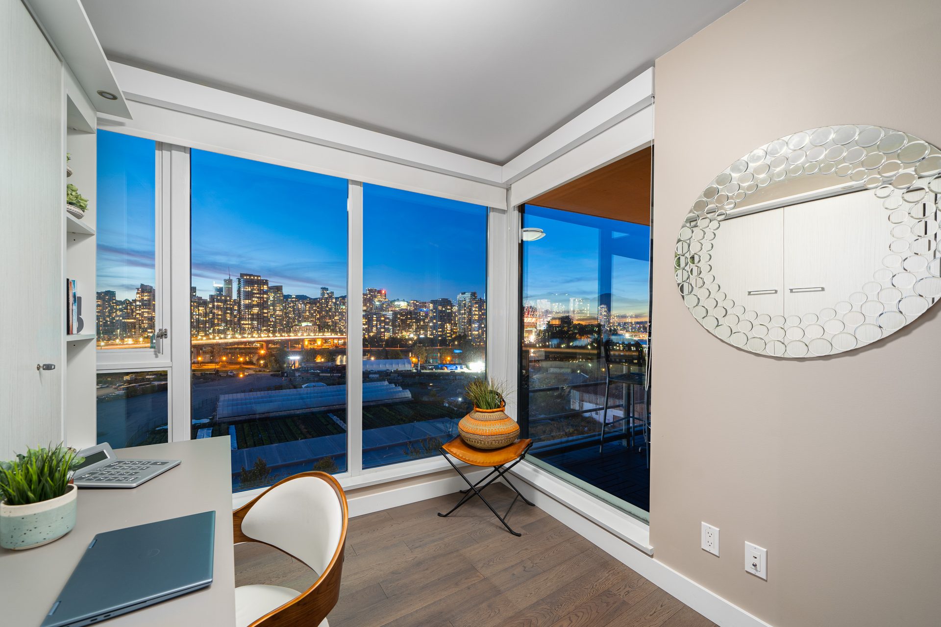 Corner of the home office at 1107-288 West 1st Avenue at dusk, with a desk and built-in cabinetry