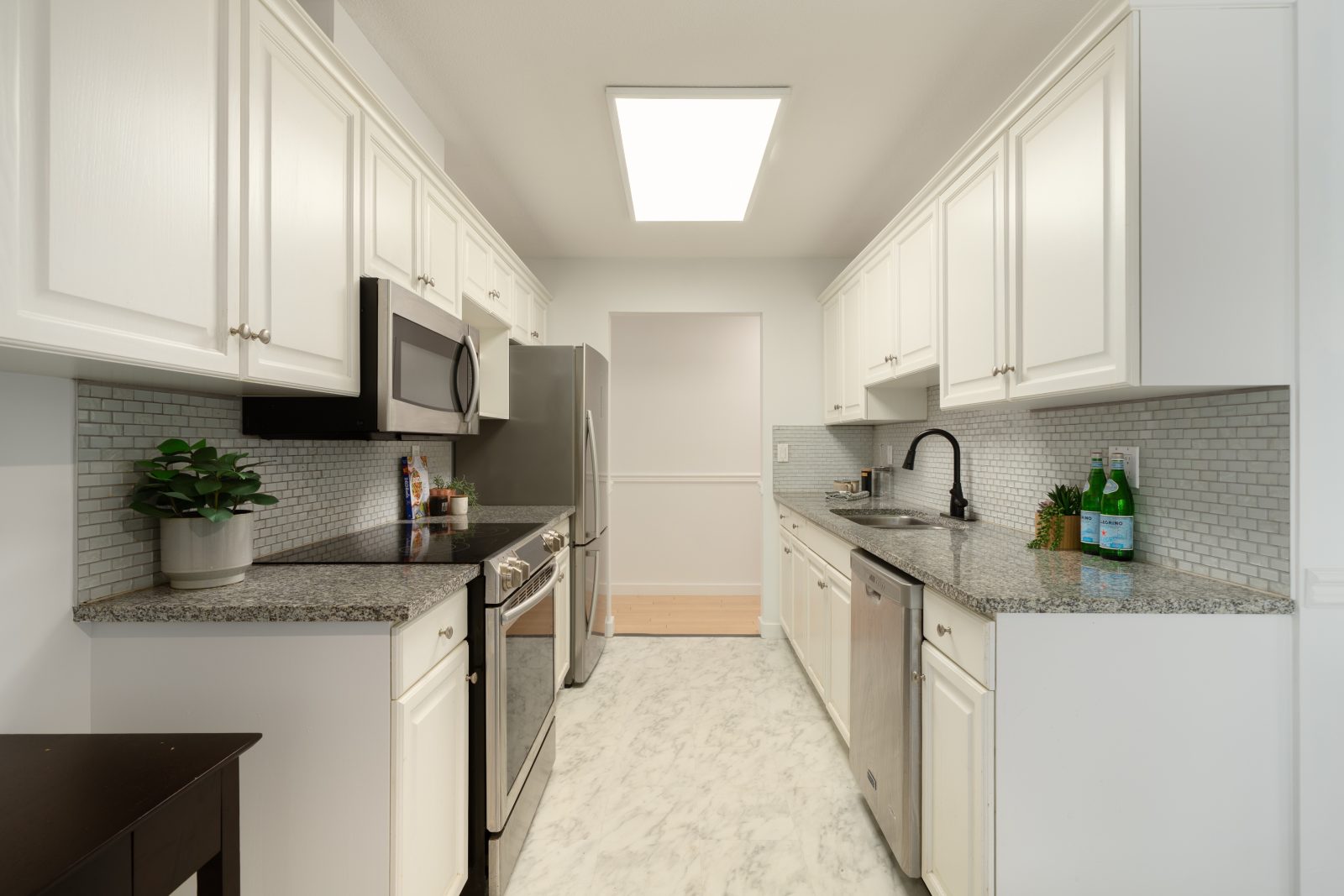 Kitchen at #105 20240 54A Avenue, Langley City, with white cabinets, granite-look counters and stainless appliances