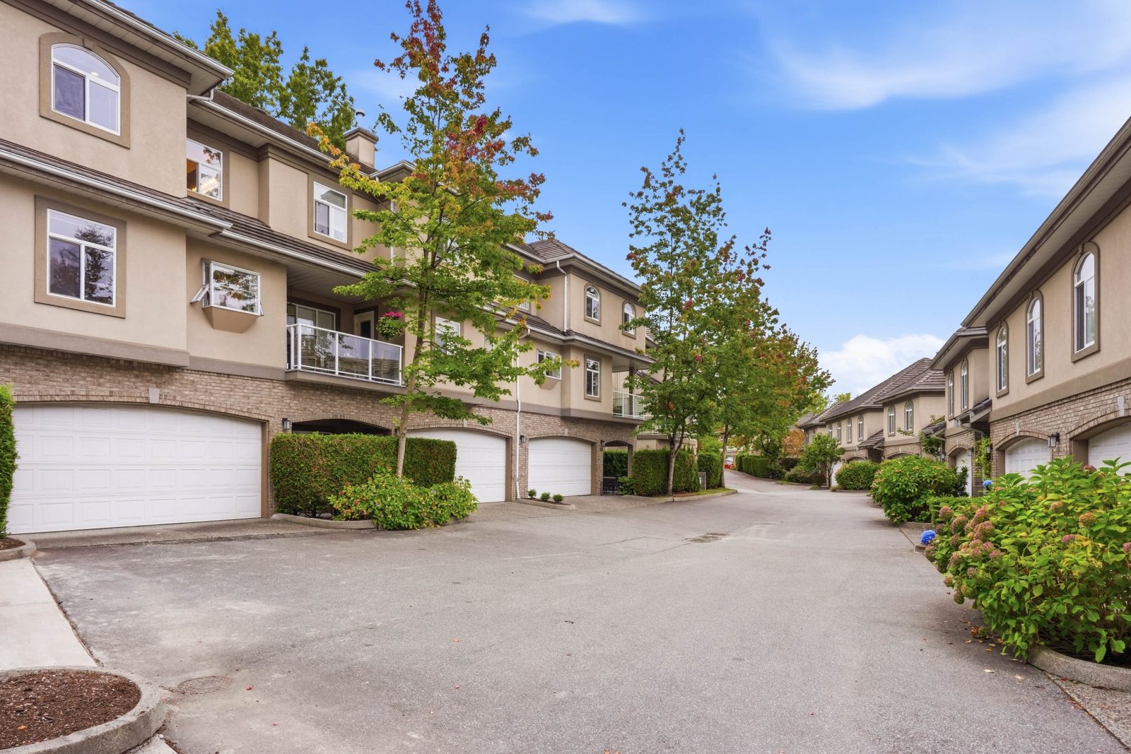 Brittany Place townhomes with brick lower levels, stucco upper floors and landscaped hedges