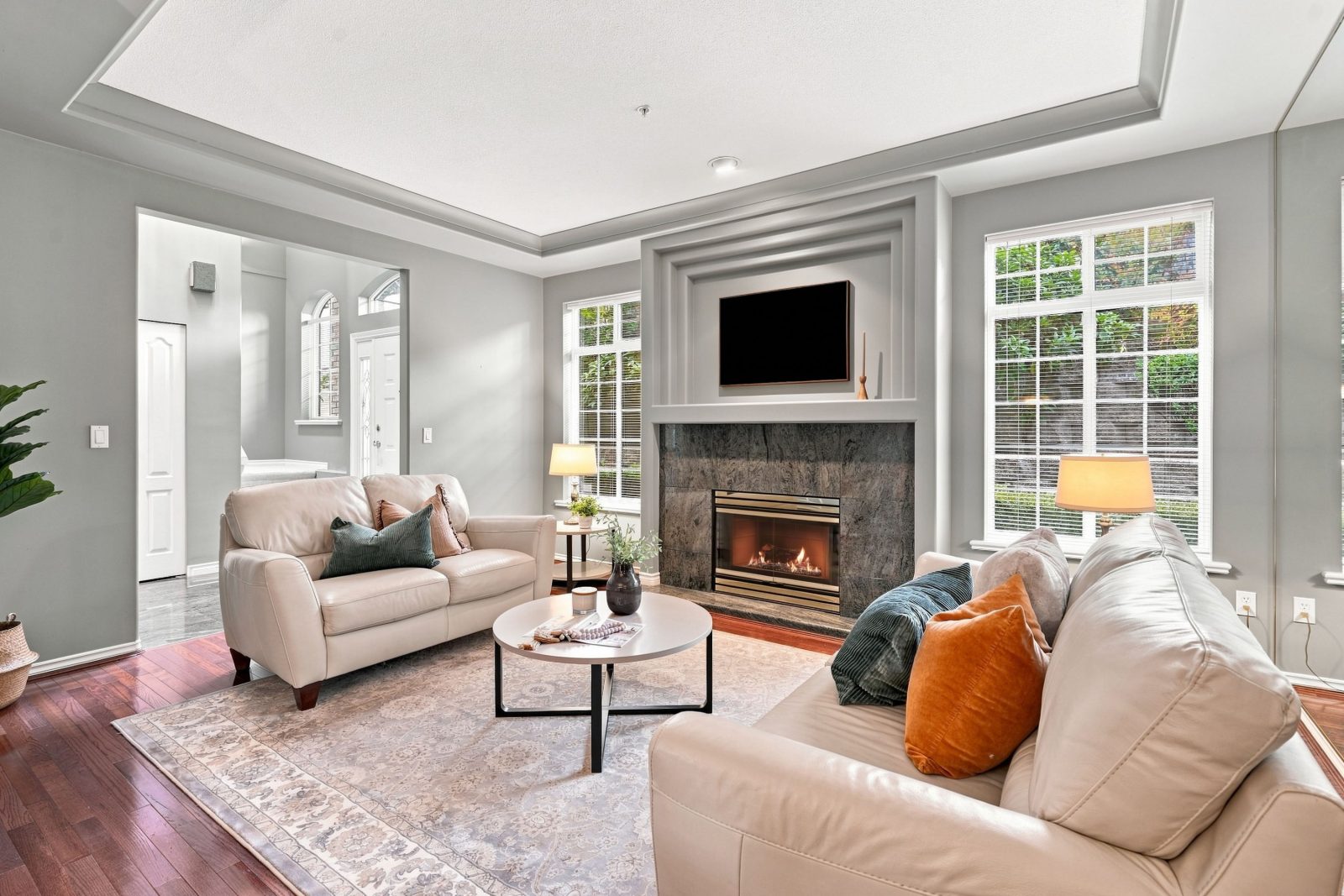 Living room at #11 915 Fort Fraser Rise with fireplace, tall windows and hardwood floors