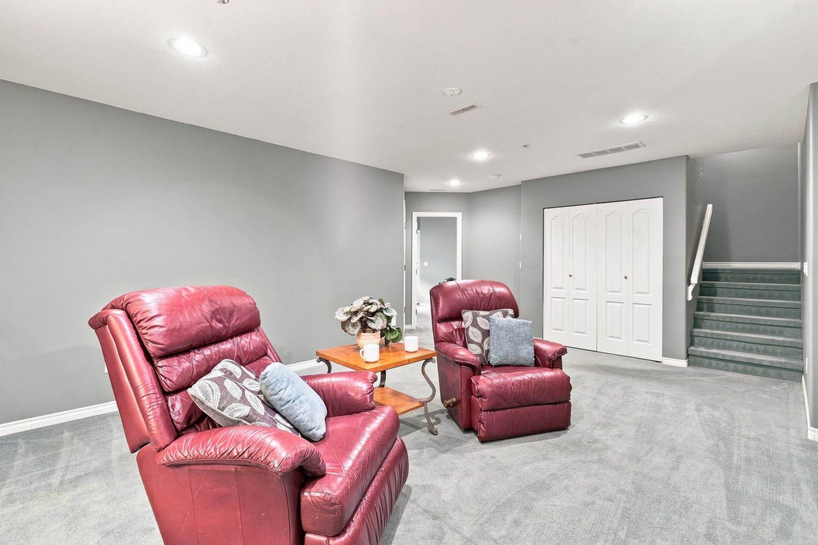 Another view of the lower-level recreation room with stairs and closet at #11 915 Fort Fraser Rise