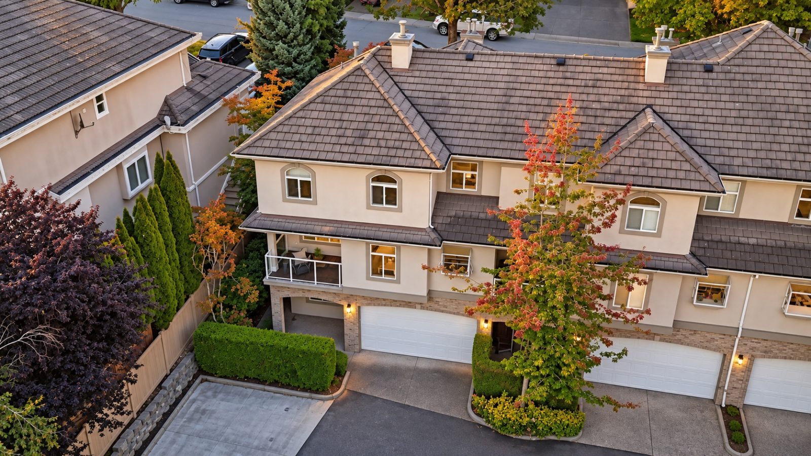 Aerial view of the end-unit townhome at #11 915 Fort Fraser Rise, Port Coquitlam, showing its double garage, covered balcony and mature landscaping