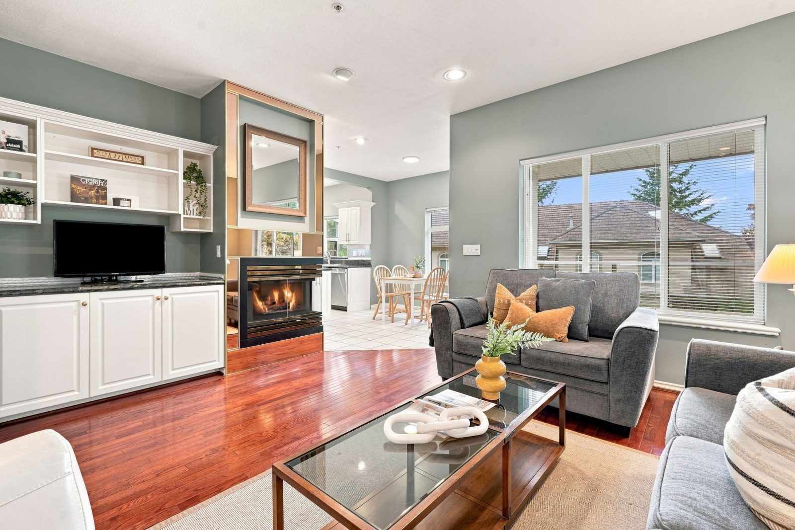 Family room with fireplace, built-in shelving and hardwood floors at #11 915 Fort Fraser Rise