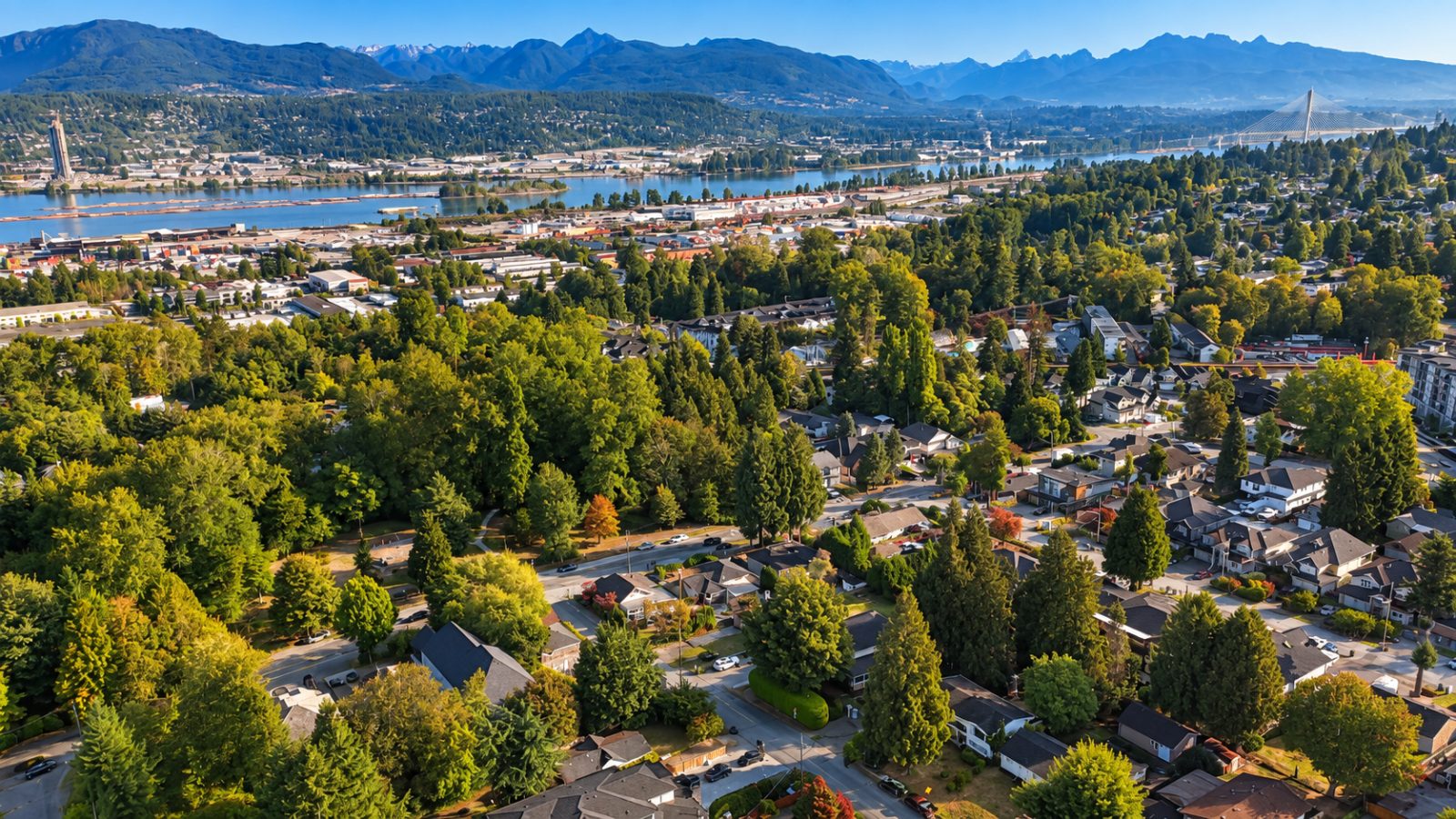 Aerial view over the Whalley neighbourhood of Surrey with the Fraser River and mountains in the distance